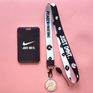A multipurpose student ID card holder neck strap lanyard featuring a daisy pattern with a transparent window for ID display, adorned with a black strap and white flowers.