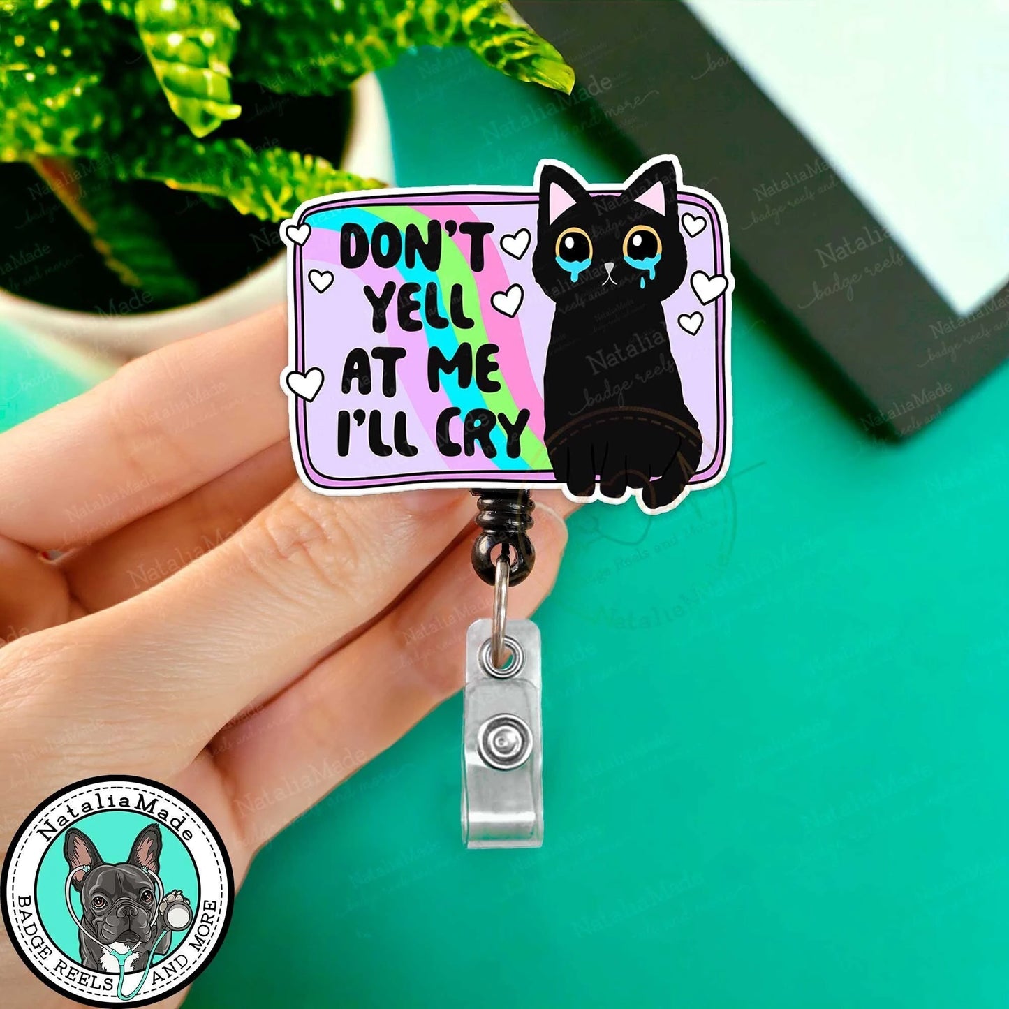 Badge holder with a black cat illustration and text 'Don't yell at me I'll cry' on a teal background.