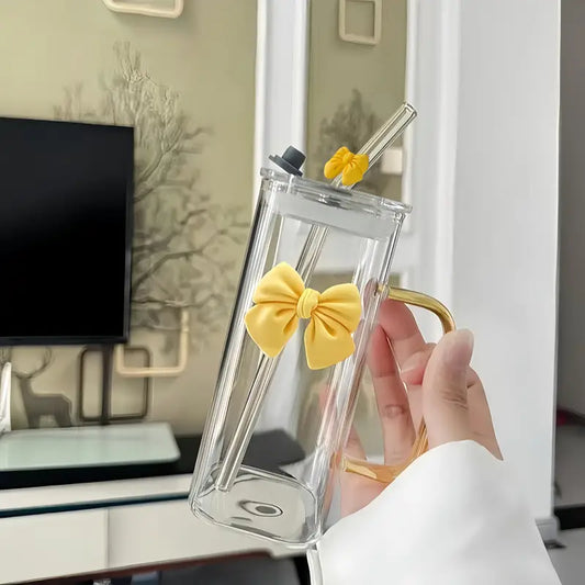 Clear phone case with yellow bow design held by a hand in an indoor setting.