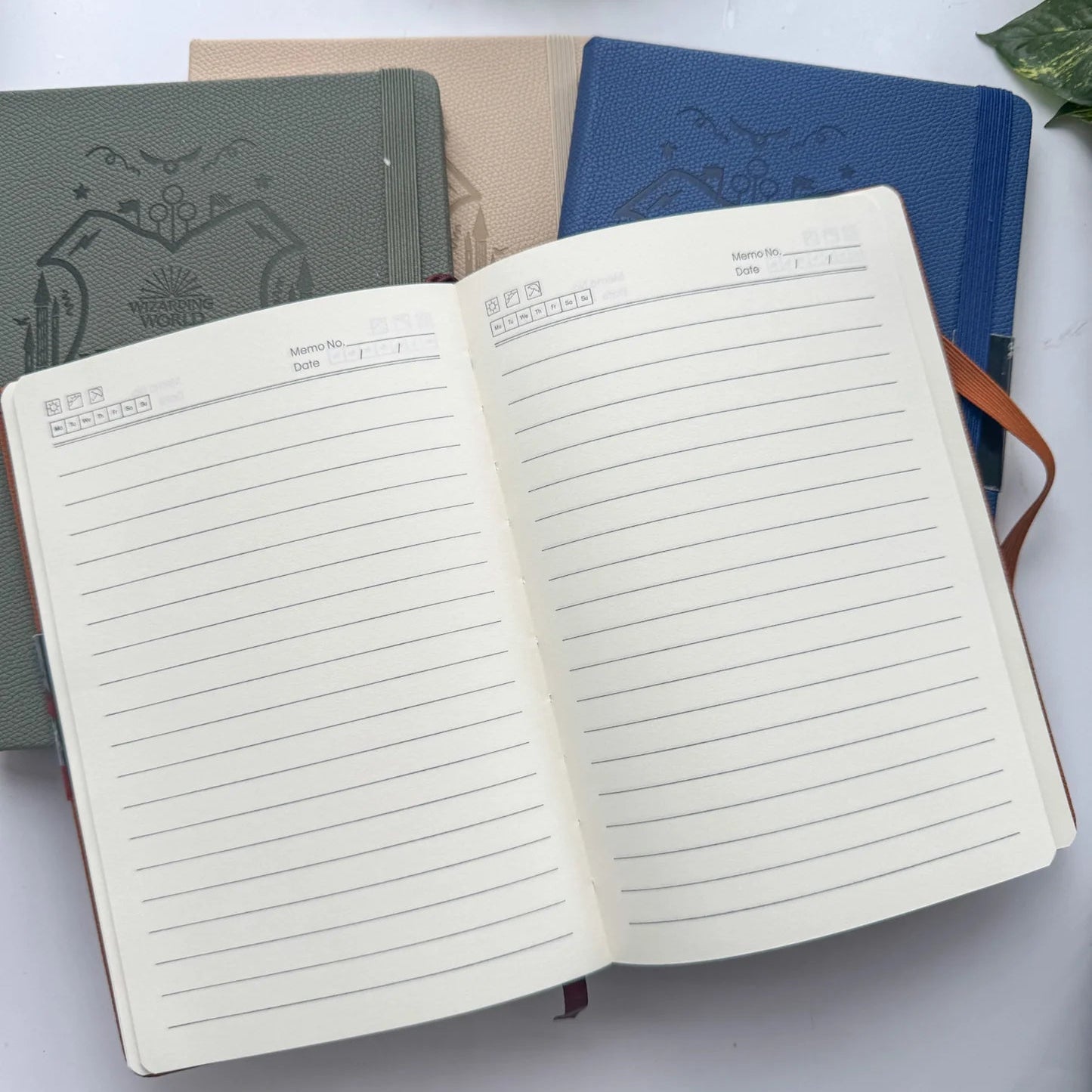 Open notebook with lined pages on a white surface with other notebooks in the background.