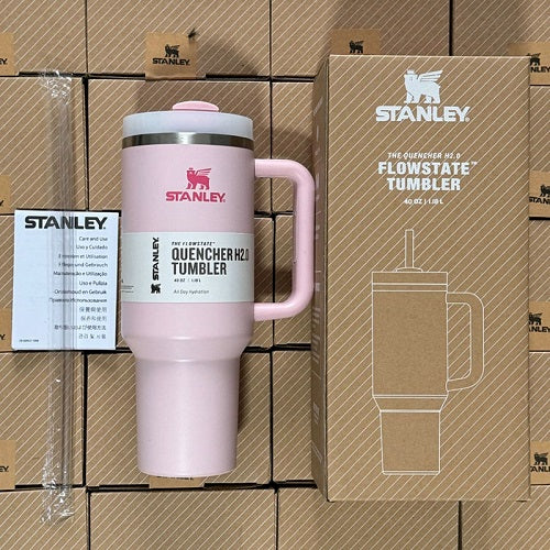 Pink Stanley tumbler with packaging on a cardboard background
