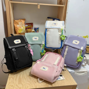 A collection of Japanese retro style schoolbags and backpacks in various colors displayed on a table.