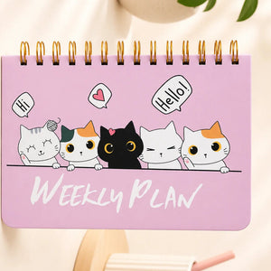 Pink weekly planner with cartoon cat designs on a light background