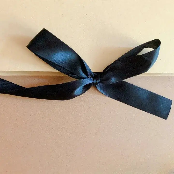 Black ribbon tied in a bow on a beige background