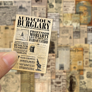 Miniature newspaper clipping held by a finger with a blurred collage of vintage newspaper clippings in the background.