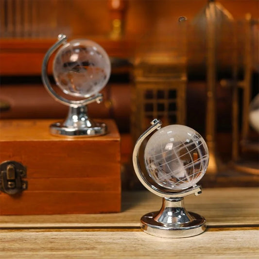 Two crystal globes on wooden stands with a blurred background