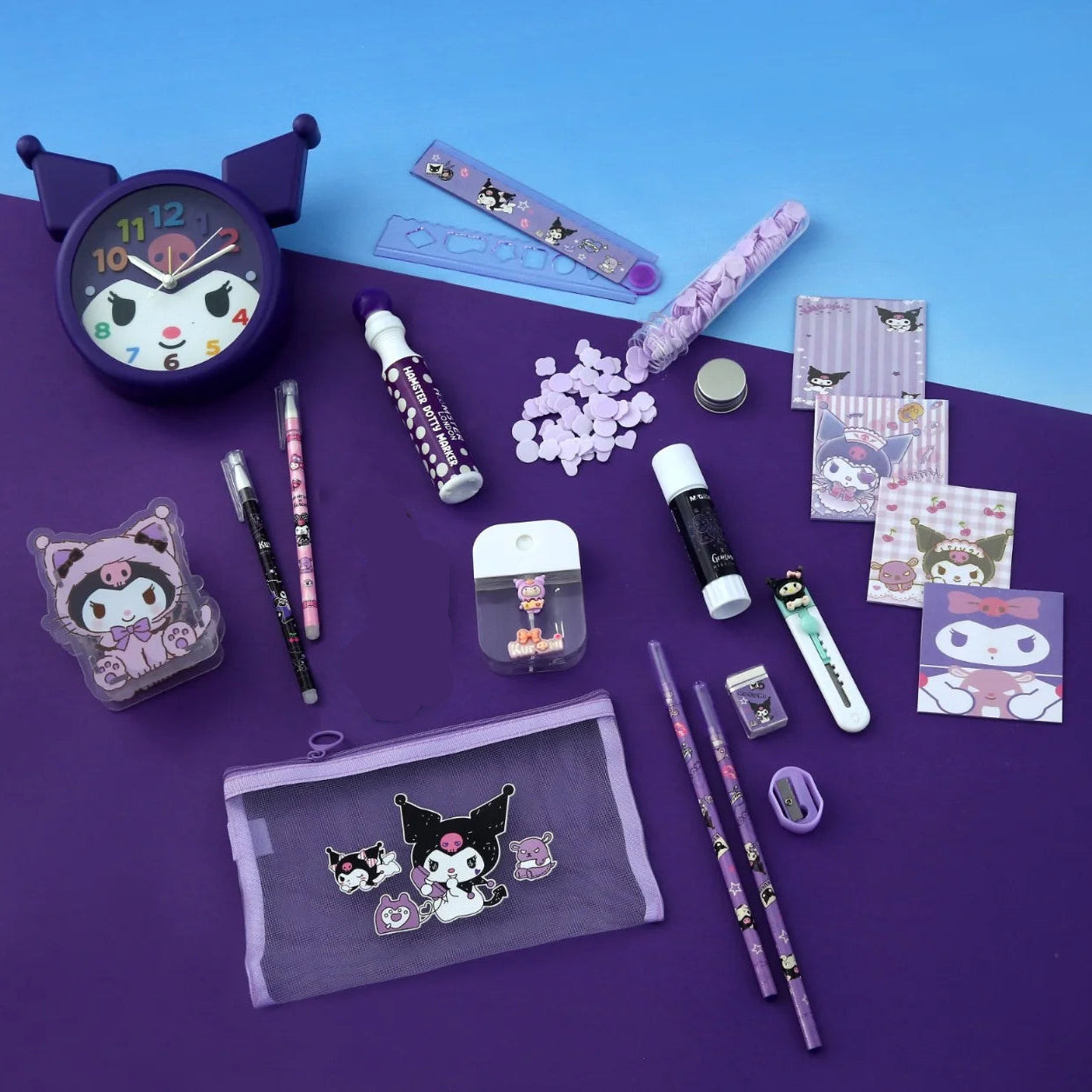 Collection of stationery items with cat-themed designs on a purple surface.