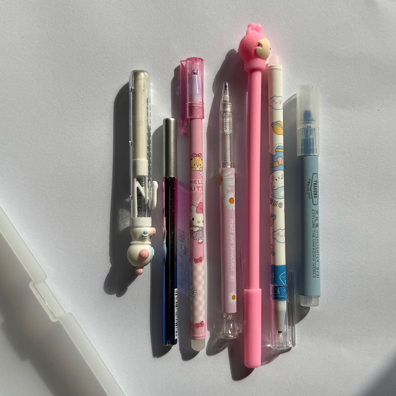 Collection of colorful pens and markers on a white surface