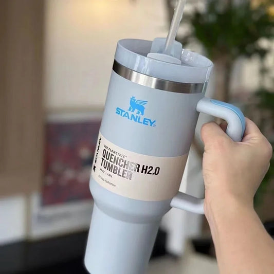 Hand holding a Stanley Quencher H2.0 tumbler with a straw lid.