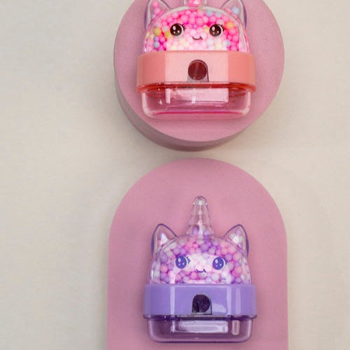 Two cartoonish hair tie and clip sets on pink stands against a light gray background