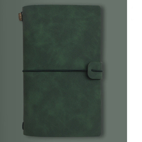 Green notebook with A6 size label on a gray background