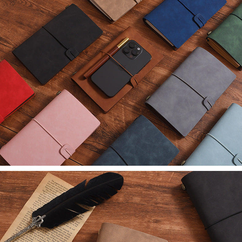 Collection of leather wallets and phone cases on a wooden surface with a feather and paper.