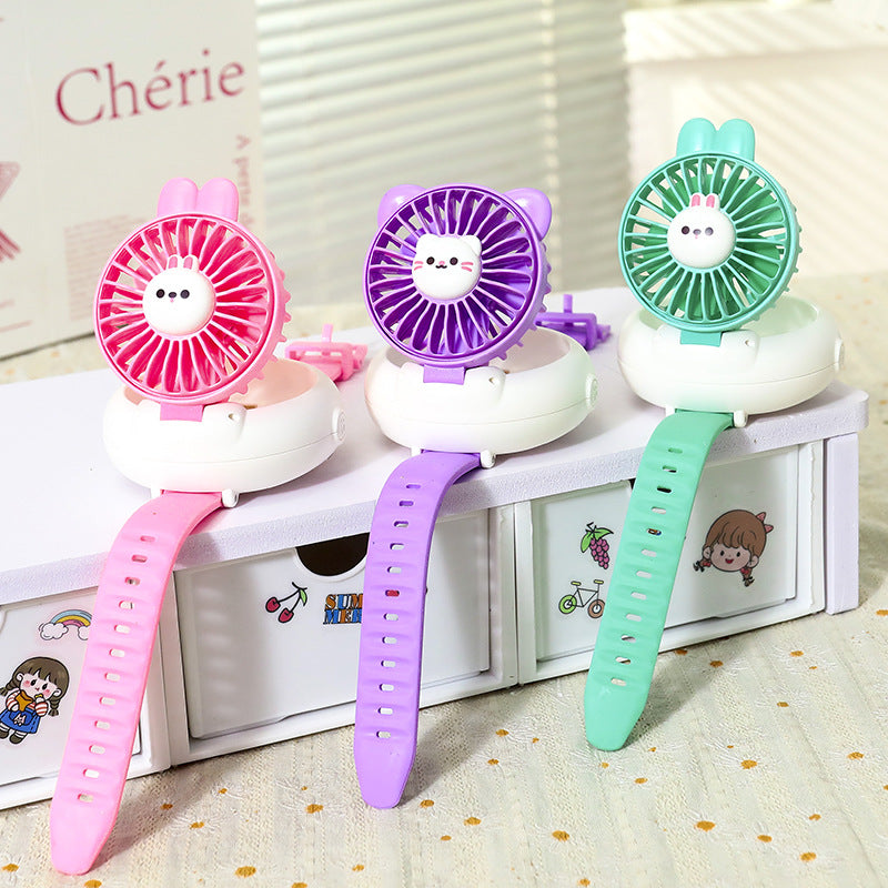 Three colorful handheld fans with cartoon faces on a white surface.