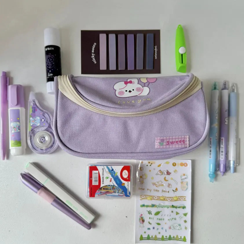 Assorted stationery items including a purple pouch, pens, markers, and stickers on a white background.