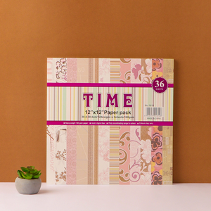 A pack of decorative journaling paper with floral patterns displayed against an orange background, with a small potted plant to the side.