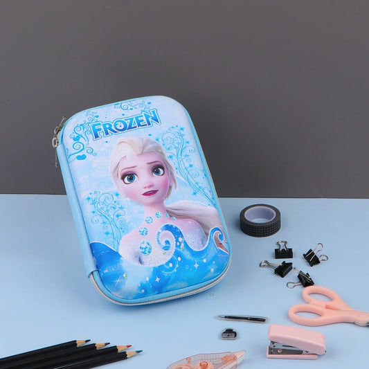 Three Frozen theme pencil cases with character illustrations, displayed alongside stationery items such as pencils and a makeup brush.