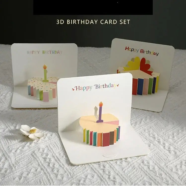 Set of 3D birthday cards with cake and candle designs on a textured surface.