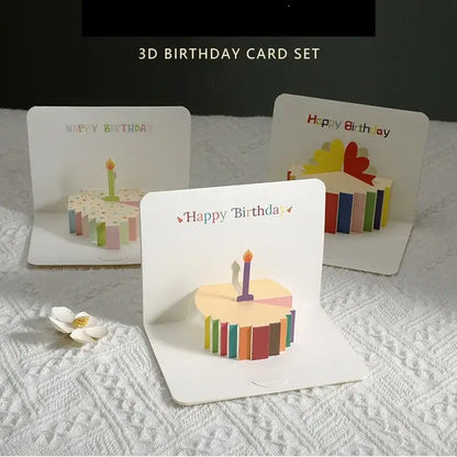 Set of 3D birthday cards with cake and candle designs on a textured surface.