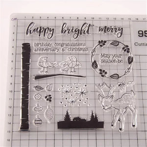 Set of clear stamps with various designs including a deer, trees, and text on a grid background.
