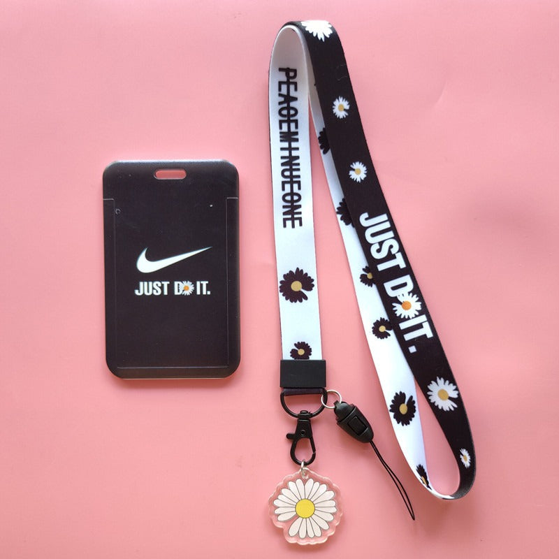 A multipurpose student ID card holder neck strap lanyard featuring a daisy pattern with a transparent window for ID display, adorned with a black strap and white flowers.