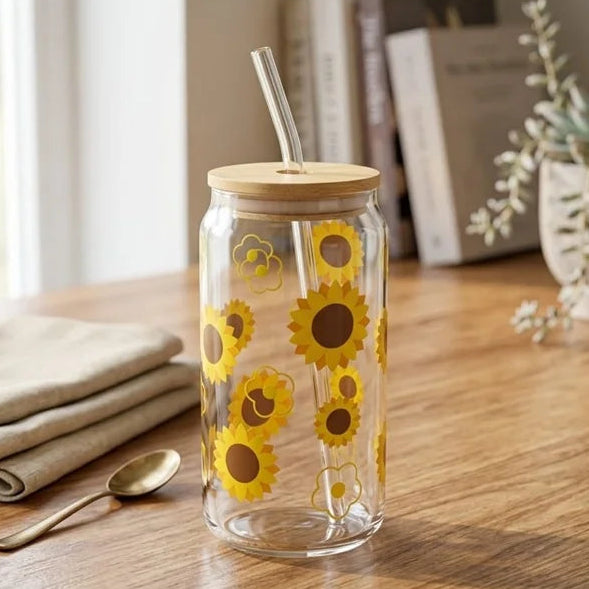 Clear glass tumbler with sunflower design on a wooden table