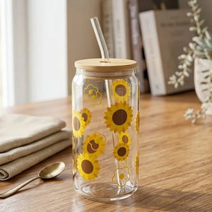 Clear glass tumbler with sunflower design on a wooden table