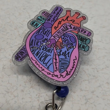 Colorful heart-shaped badge holder with text on a light gray background