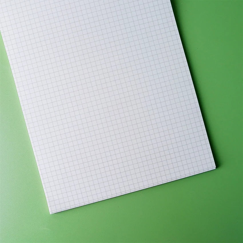 Three B5 size notepads with soft frosted covers, displaying different page patterns: blank, grid, and lined, on a green background.