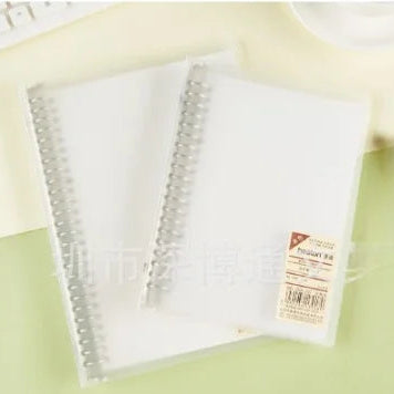 Clear plastic sheet with a spiral binding on a light green surface