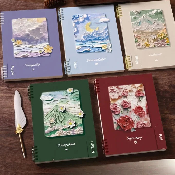 Five notebooks with artistic covers on a wooden surface, with a pen and paper in the foreground.