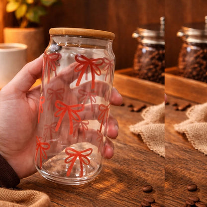 Glass jar with wooden lid held by a hand on a wooden surface with coffee beans.