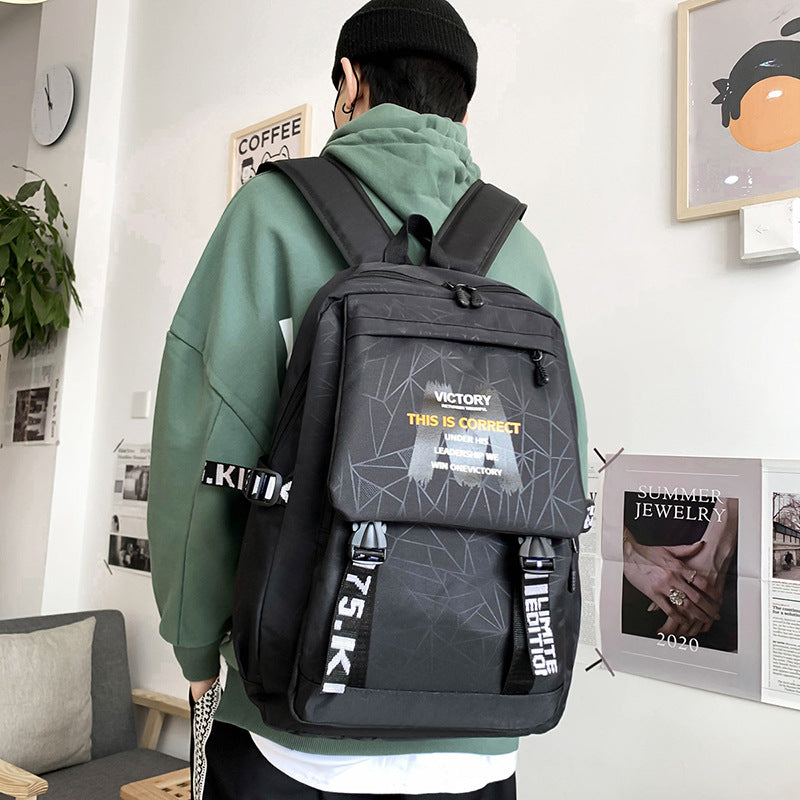 Person wearing a black backpack with geometric design and text in a room.