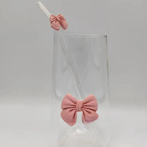 Clear glass with pink bow-shaped stoppers on a white background