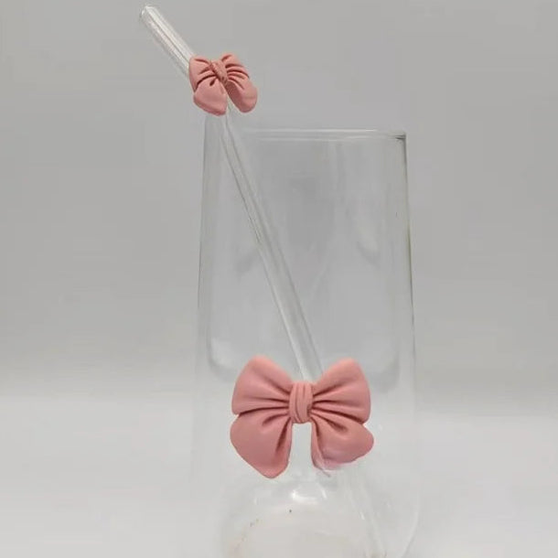 Clear glass with pink bow-shaped stoppers on a white background