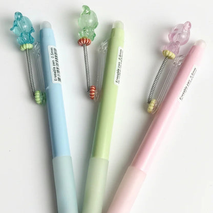 Four colorful pens with decorative ends on a white background