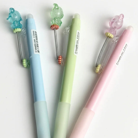 Four colorful pens with decorative ends on a white background
