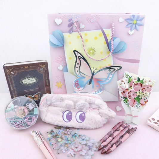 Pastel-colored stationery items including a notebook, pouch, and pens on a light pink background.