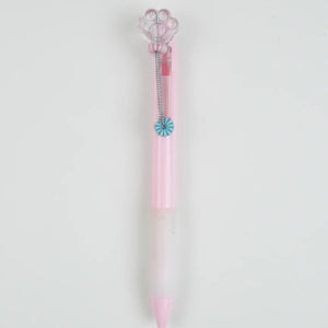 Pink and clear pen with decorative elements on a light gray background
