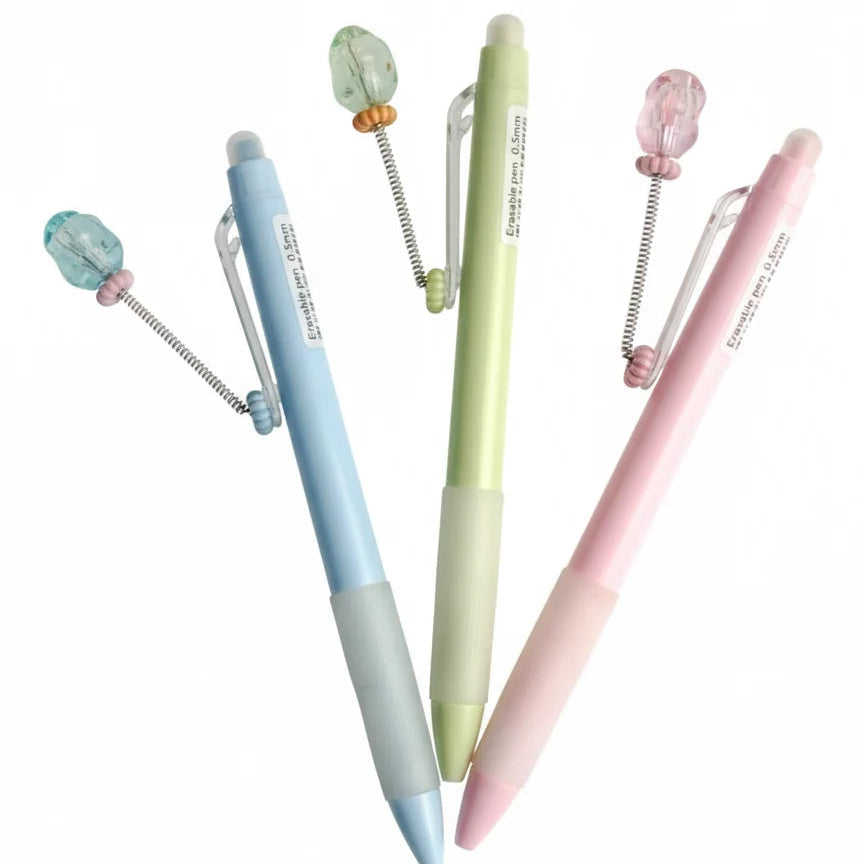 Three pastel-colored pens with decorative elements on a white background