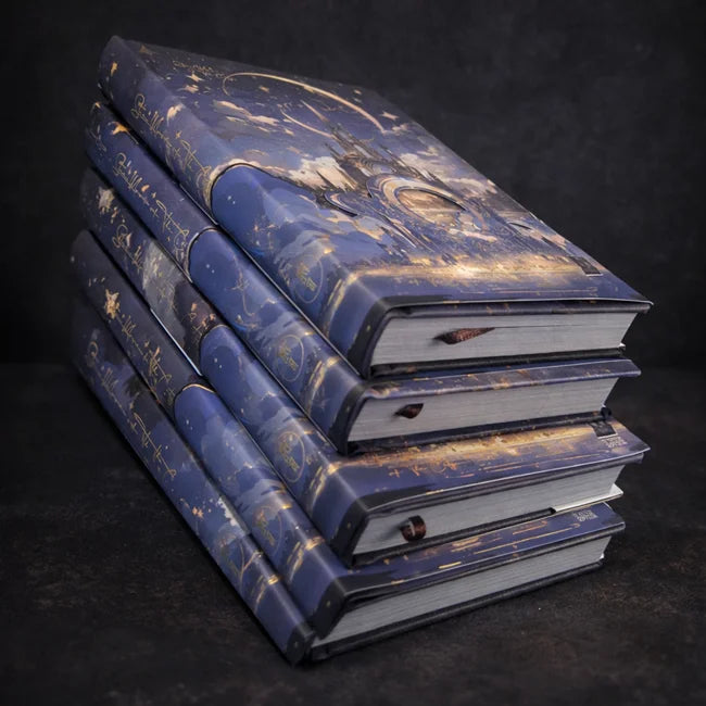 Stack of decorative blue books with celestial design on a dark background