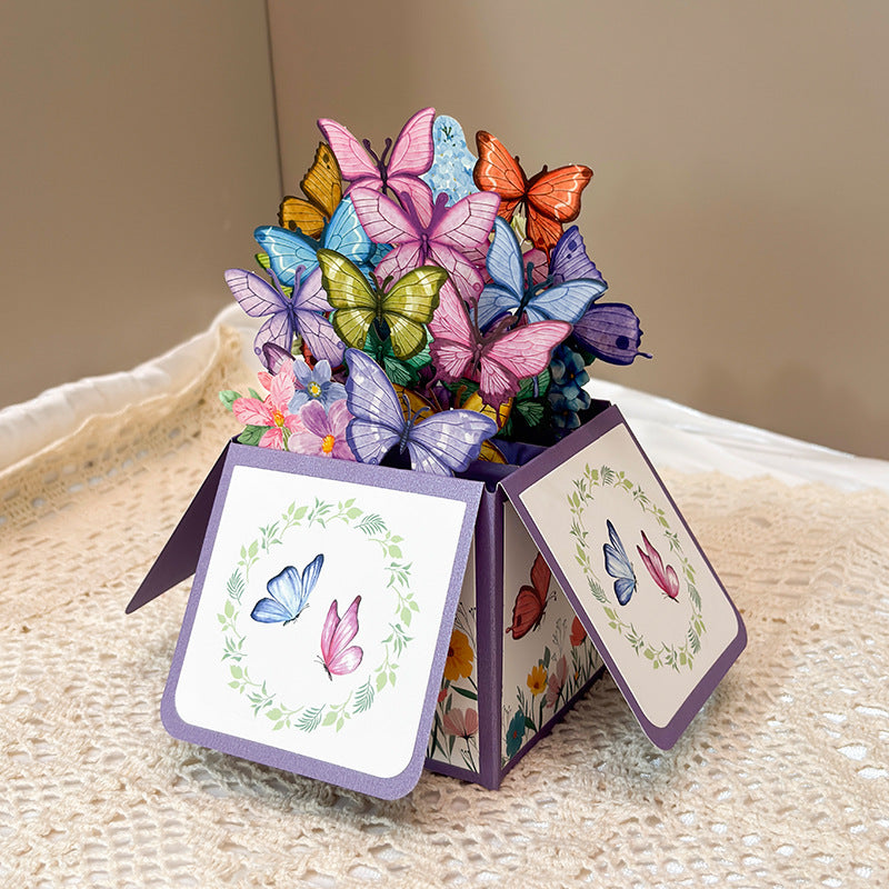 Pop-up card with colorful butterflies and flowers on a textured surface