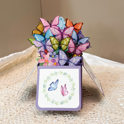 Pop-up card with colorful butterflies and flowers on a textured surface
