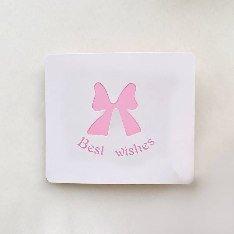 White card with a pink bow and 'Best wishes' text on a light beige background