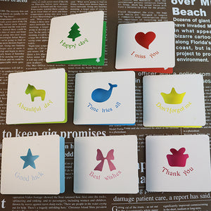 Set of small cards with various symbols and text on a newspaper background
