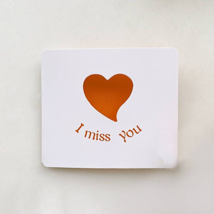 Card with an orange heart and 'I miss you' text on a white background