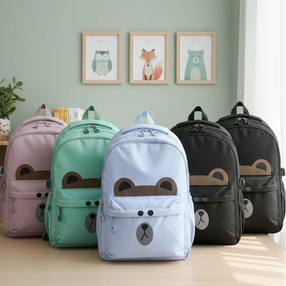 Set of colorful backpacks with bear designs on a wooden table against a light green wall.