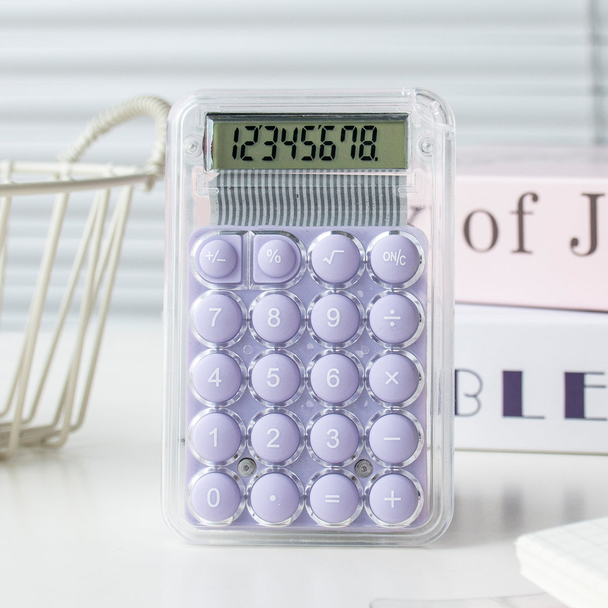 Purple calculator with a clear plastic cover on a light background
