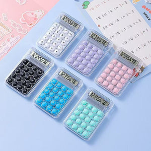 Set of colorful calculators with different colored buttons on a light blue background.