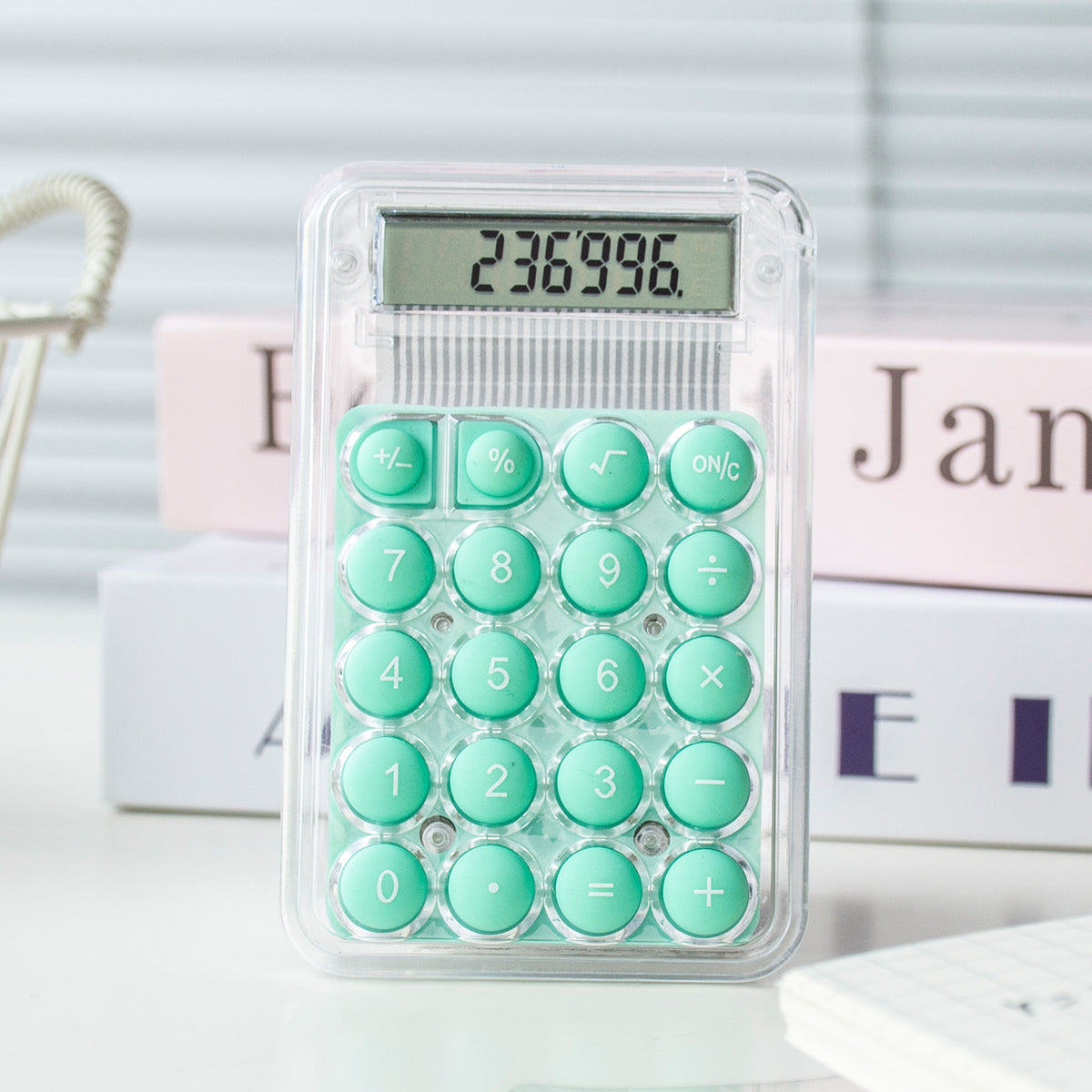 Calculator with green buttons on a white surface