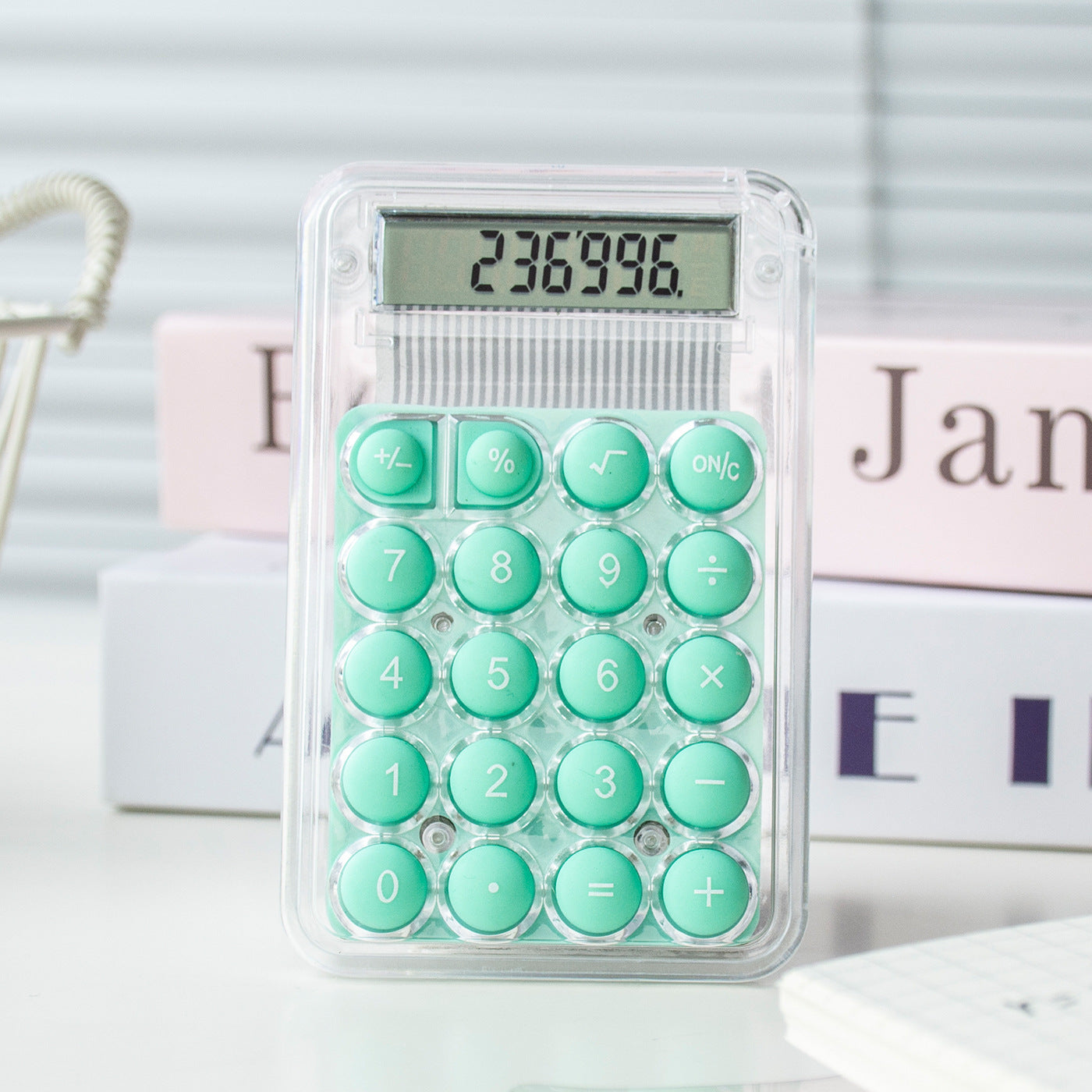 Calculator with green buttons on a white surface